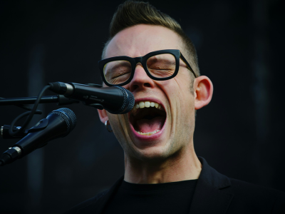 a man singing into a microphone with superior sound