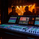 digital mixer with a people in the background and stage