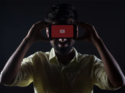a man holding cell phone over his face showing streaming platforms